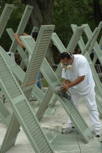 Shutter, Professional painter preparing shutters for painting with primer and tools, part of Hands On Painters’ shutter and trim restoration services.